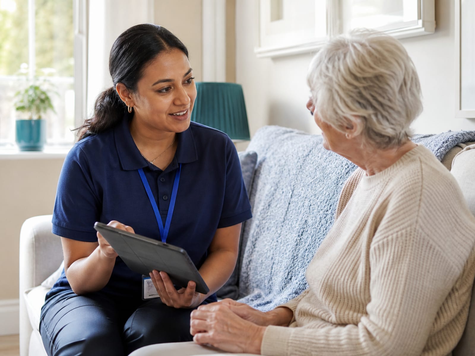 A care worker discusses a care plan with an older adult at home.